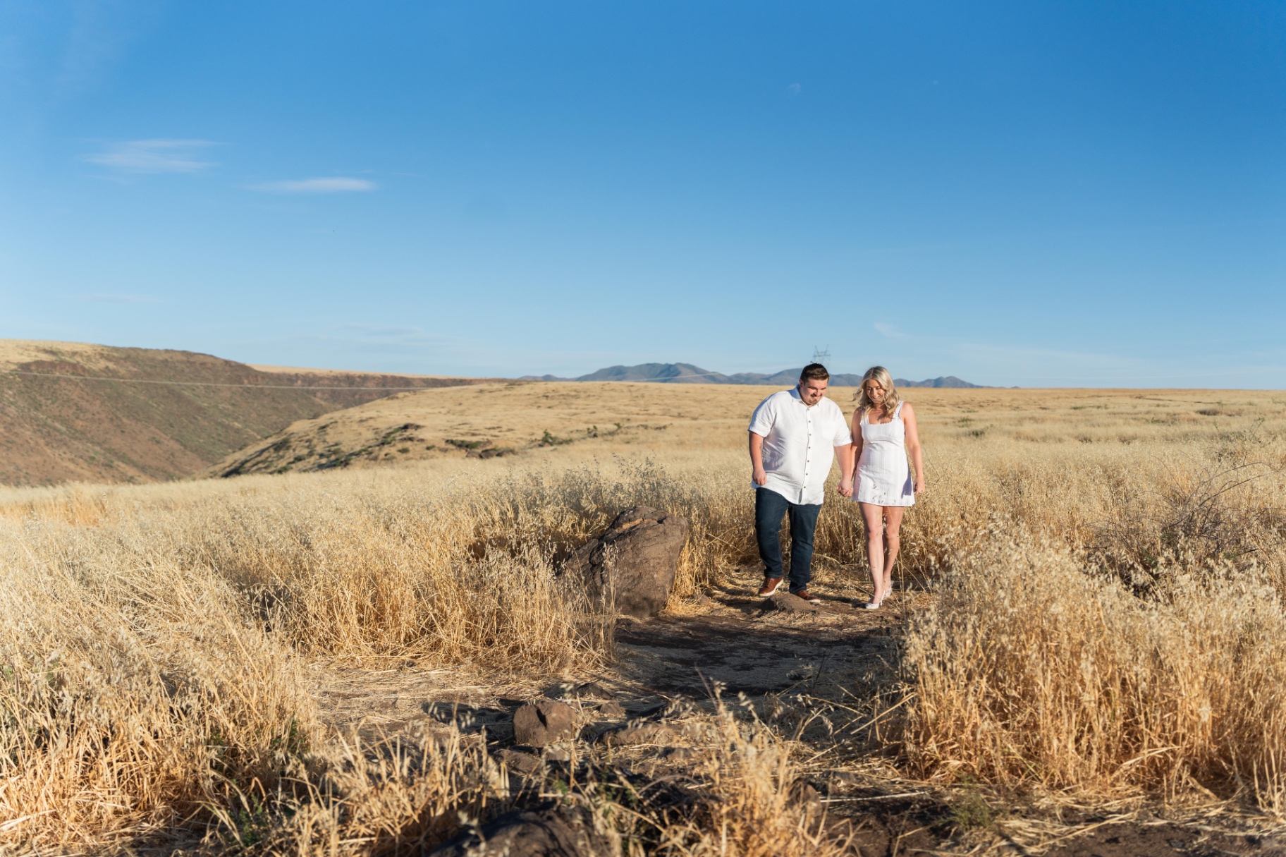 Molly and Noah walking hand in hand through the desert landscape